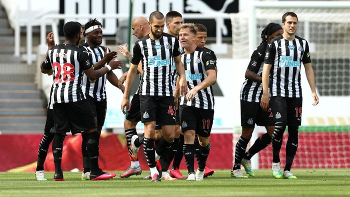 NEWCASTLE UPON TYNE, ENGLAND - JULY 26: Newcastle United players celebrate their teams first goal during the Premier League match between Newcastle United and Liverpool FC at St. James Park on July 26, 2020 in Newcastle upon Tyne, England. Football Stadiums around Europe remain empty due to the Coronavirus Pandemic as Government social distancing laws prohibit fans inside venues resulting in all fixtures being played behind closed doors. (Photo by Jan Kruger/Getty Images )