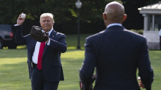 President Donald Trump plays catch with former New York Yankees Hall of Fame pitcher Mariano Rivera as he greets youth baseball players on the South Lawn of the White House to mark Opening Day for Major League Baseball, Thursday, July 23, 2020, in Washington. (AP Photo/Evan Vucci)