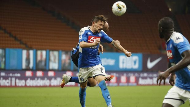 Napoli's Mario Rui, foreground, fights for the ball with Inter Milan's Borja Valero, obscured, during the Serie A soccer match between= Inter Milan and Napoli at the San Siro Stadium, in Milan, Italy, Tuesday, July 28, 2020. (AP Photo/Antonio Calanni)