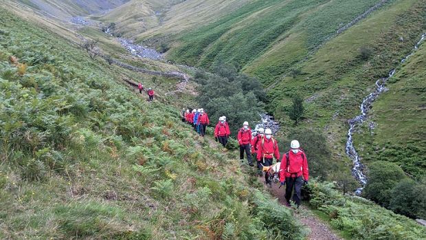 Volunteers from Wasdale mountain rescue team take turns to carry 121lb (55kg) St Bernard dog, Daisy from England's highest peak, Scafell Pike, Sunday July 26, 2020. The mountain rescue team spent nearly five hours rescuing St Bernard dog Daisy, who had collapsed displaying signs of pain in her rear legs and was refusing to move, while descending Scafell Pike. The Wasdale Mountain Rescue team rely on public contributions to their JustGiving.com/wasdalemrt page to fund their mountain safety efforts. (Wasdale Mountain Rescue via AP)