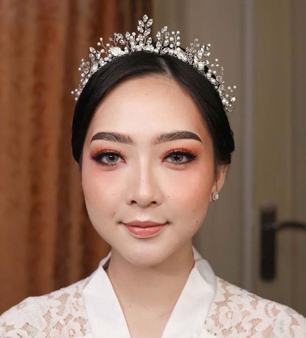 Asta Riri memilih menggunakan makeup flawless dengan nuansa oranye pada akad nikahnya.