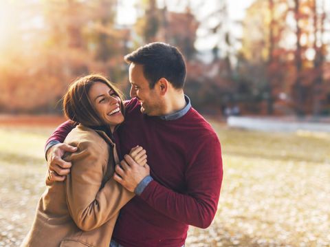 Couple in love hugging and enjoying at public park in autumn