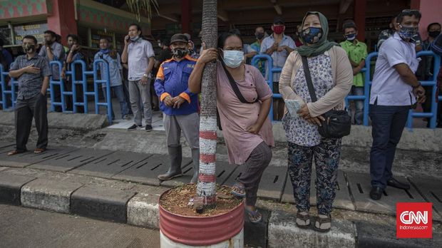 Penumpang bus antar kota antar provinsi (AKAP) di Terminal Kampung Rambutan, Jakarta, Kamis, 30 Juli 2020. Calon penumpang yang hendak menggunakan jasa armada bus luar kota diwajibkan untuk menunjukkan surat bebas influenza, hasil tes cepat atau tes usap, atau mengisi formulir Corona Likelihood Metric (CLM). CNN Indonesia/Bisma Septalisma