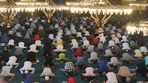 Khusuk Salat Iduladha Pertama di Hagia Sophia Muslims, wearing protective masks as a precaution against infection from coronavirus gather for the Eid al-Adha prayer inside the Byzantine-era Hagia Sophia, recently converted back to a mosque, in the historic Sultanahmet district of Istanbul, Friday, July 31, 2020. Small groups of pilgrims performed one of the final rites of the Islamic hajj on Friday as Muslims worldwide marked the start of the Eid al-Adha holiday amid a global pandemic that has impacted nearly every aspect of this year’s pilgrimage and celebrations. The last days of hajj coincide with the four-day Eid al-Adha, or “Feast of Sacrifice,” in which Muslims slaughter livestock and distribute the meat to the poor. (Pool via AP)