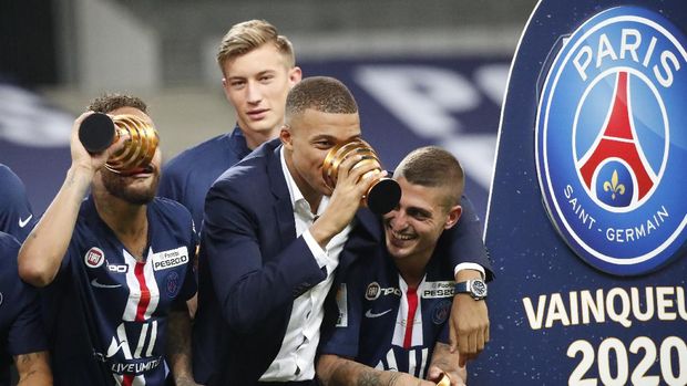 PSG's Kylian Mbappe, centre, who did not play due to an injury, celebrates with his teammates after the team won the French League Cup, following the soccer final match against Lyon at Stade de France stadium, in Saint Denis, north of Paris, Friday, July 31, 2020. (AP Photo/Francois Mori)
