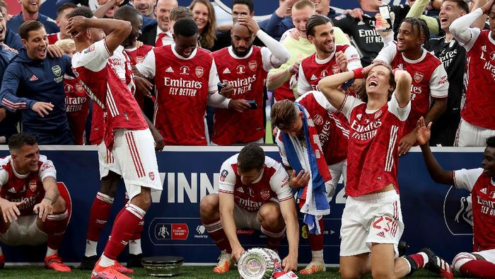Arsenal Piala FA LONDON, ENGLAND - AUGUST 01: Pierre-Emerick Aubameyang of Arsenal drops the FA Cup Trophy before lifting it with his team mates after their victory in the Heads Up FA Cup Final match between Arsenal and Chelsea at Wembley Stadium on August 01, 2020 in London, England. Football Stadiums around Europe remain empty due to the Coronavirus Pandemic as Government social distancing laws prohibit fans inside venues resulting in all fixtures being played behind closed doors. (Photo by Catherine Ivill/Getty Images)