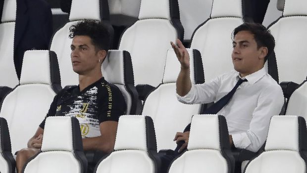 Juventus' Cristiano Ronaldo, left, and Juventus' Paulo Dybala gesture as attend a Serie A soccer match between Juventus and Roma, at the Allianz stadium in Turin, Italy, Saturday, Aug.1, 2020. (AP Photo/Luca Bruno)