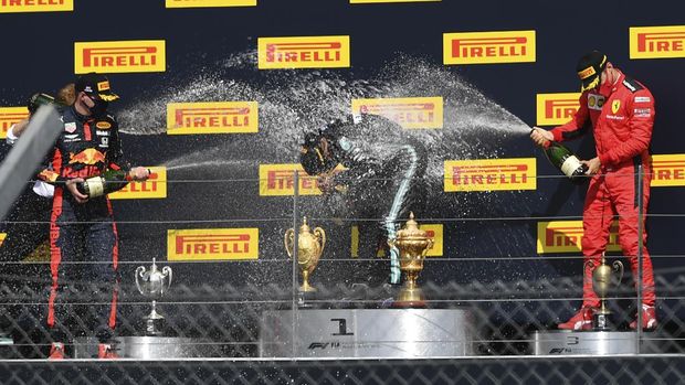 Mercedes driver Lewis Hamilton of Britain, center, celebrates his victory on the podium with second placed Red Bull driver Max Verstappen of the Netherlands, left and third placed Ferrari driver Charles Leclerc of Monaco the British Formula One Grand Prix at the Silverstone racetrack, Silverstone, England, Sunday, Aug. 2, 2020. (Ben Stansall/Pool via AP)