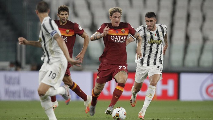 Romas Nicolo Zaniolo, center, runs with the ball between Juventus Simone Muratore, right, and Juventus Leonardo Bonucci during a Serie A soccer match between Juventus and Roma, at the Allianz stadium in Turin, Italy, Saturday, Aug.1, 2020. (AP Photo/Luca Bruno)
