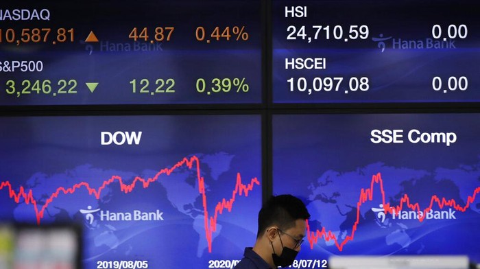 RESESI People wearing face masks walk by an electronic stock board of a securities firm in Tokyo, Monday, Aug. 3, 2020. Asian shares were mixed on Monday, as investors watched surging numbers of new coronavirus cases in the region, including in Japan. (AP Photo/Koji Sasahara)