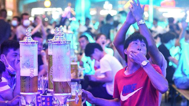 This photo taken on August 1, 2020 shows people enjoying beer and food during the annual Qingdao Beer Festival in Qingdao, in China's eastern Shandong province. - Thousands of Chinese beer lovers left their facemasks and virus worries behind to gather in large crowds and raise a much-needed glass as the annual Qingdao beer festival opened over the weekend. (Photo by STR / AFP) / China OUT