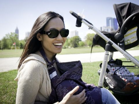 Young Mother breastfeeding her Baby in a Park. Chinese / Asian ethnicity. Photo taken in Piedmont Park, Atlanta, Georgia, USA.