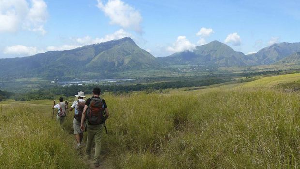Lombok, Indonesia - 26th August 2013. Panoramic view of the natural park of Rinjani, on the island of Lombok. Three hikers descending the mountain in the middle of nature.