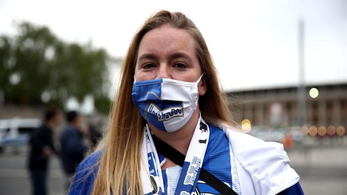 BERLIN, GERMANY - MAY 22: A fan wears a protective face mask outside the Olympiastadion during the Bundesliga match between Hertha Berlin and Union Berlin during the coronavirus crisis on May 22, 2020 in Berlin, Germany. The Bundesliga, after shutting down all its games in March due to lockdown measures against the spread of the virus, resumed matches last week, albeit in empty stadiums. Fans are mostly watching the games live from home or at the first pubs that have been allowed to reopen. (Photo by Maja Hitij/Getty Images)