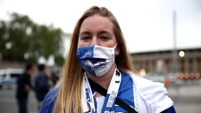 Bundesliga BERLIN, GERMANY - MAY 22: A fan wears a protective face mask outside the Olympiastadion during the Bundesliga match between Hertha Berlin and Union Berlin during the coronavirus crisis on May 22, 2020 in Berlin, Germany. The Bundesliga, after shutting down all its games in March due to lockdown measures against the spread of the virus, resumed matches last week, albeit in empty stadiums. Fans are mostly watching the games live from home or at the first pubs that have been allowed to reopen. (Photo by Maja Hitij/Getty Images)