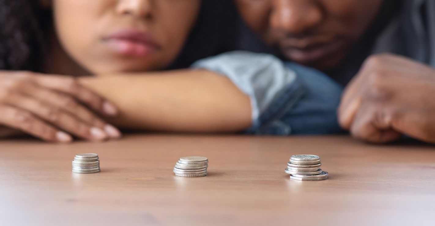 Poverty And Absence Of Money Concept. Stacks Of Coins Lying On Table In Front Of Sad African American Couple, Crop