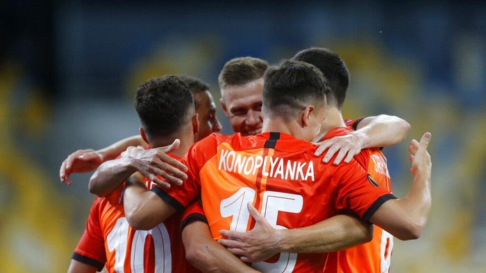Shakhtars Junior Moraes, left, celebrates with teammates after scoring his sides opening goal during the Europa League round of 16 second leg soccer match between FC Shakhtar Donetsk and VfL Wolfsburg at the Olimpiyskiy Stadium in Kyiv, Ukraine, Wednesday, Aug. 5, 2020. (AP Photo/Efrem Lukatsky)