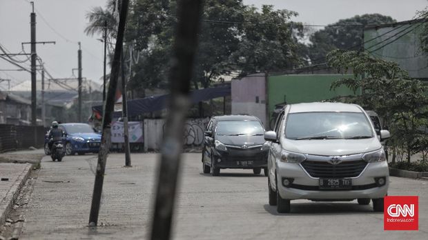 Sejumlah kendaraan melintas dekat tiang listrik yang berada di tengah jalan di kawasan Pasar Minggu, Jakarta, Jumat, 7 Agustus 2020. Tiang listrik tersebut terdampak pembangunan pelebaran jalan yang dilakukan di kawasan itu, namun, keberadaan tiang listrik yang tidak pada jalurnya ini dapat membahayakan pengendara yang sedang melintas di jalan tersebut. CNN Indonesia/Bisma Septalisma