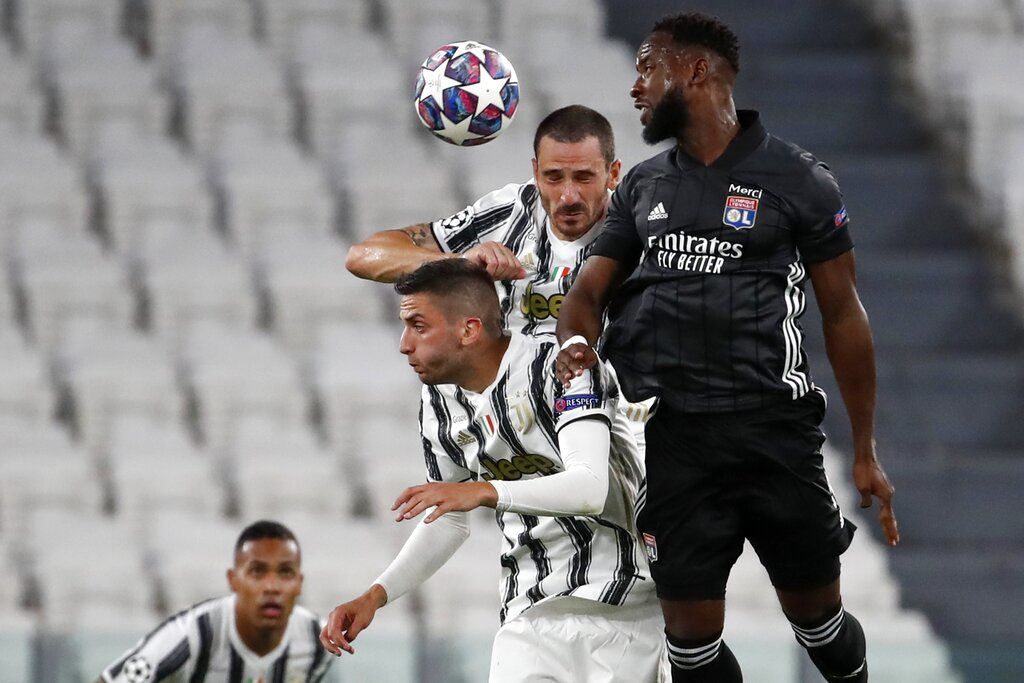Juventus' Rodrigo Bentancur, left, his teammate Leonardo Bonucci, center, and Lyon's Moussa Dembele jump for the ball during the Champions League round of 16 second leg, soccer match between Juventus and Lyon at the Allianz stadium in Turin, Italy, Friday, Aug. 7, 2020. (AP Photo/Antonio Calanni)