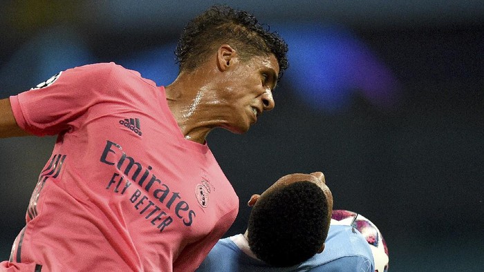 Real Madrids Raphael Varane jumps for a header with Manchester Citys Gabriel Jesus during the Champions League, round of 16, second leg soccer match between Manchester City and Real Madrid at the Etihad Stadium in Manchester, England, Friday, Aug. 7, 2020. (Oli Scarff/Pool Photo via AP)
