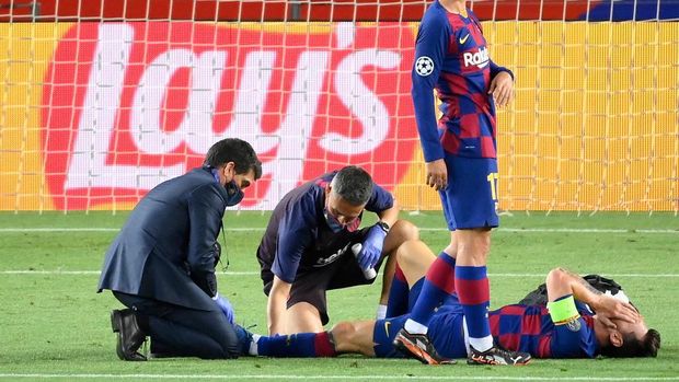 Barcelona's Argentine forward Lionel Messi reacts on the football pitch after being injured during the UEFA Champions League round of 16 second leg football match between FC Barcelona and Napoli at the Camp Nou stadium in Barcelona on August 8, 2020. (Photo by LLUIS GENE / AFP)