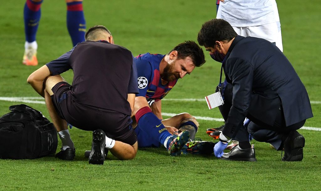 BARCELONA, SPAIN - AUGUST 08: Lionel Messi of Barcelona is seen to by medical staff after sustaining an injury during the UEFA Champions League round of 16 second leg match between FC Barcelona and SSC Napoli at Camp Nou on August 08, 2020 in Barcelona, Spain.  (Photo by David Ramos/Getty Images)