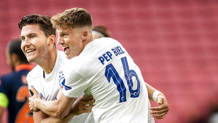 Copenhagens Jonas Wind, left, celebrates scoring a goal with teammate Pep Biell, during the Europa League round of 16 second leg soccer match between FC Copenhagen and Istanbul Basaksehir, at Telia Parken in Copenhagen, Wednesday, Aug. 5, 2020. (Mads Claus Rasmussen/Ritzau Scanpix via AP)