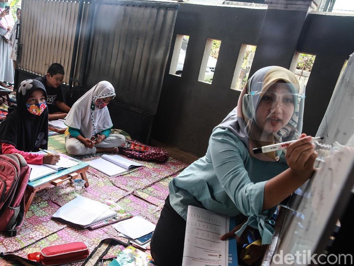 Murid kelas IV SD Muhammadiyah 37 belajar pada teras rumah seorang guru di kawasan Pondok Cabe Udik, Tangerang Selatan, Banten, Senin (10/8/2020). Kegiatan belajar mengajar (KBM) tatap muka dengan menerapkan standar protokol kesehatan ini terpaksa dilakukan karena murid kesulitan menguasai materi pelajaran saat proses belajar secara online.