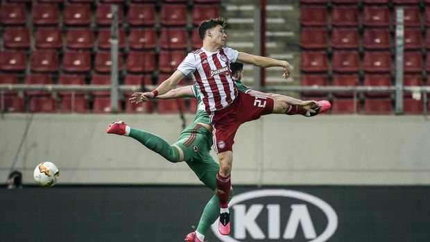 Olympiakos's Kostas Tsimikas (front) fights for the ball with Wolves's Matt Doherty during the UEFA Europa League first leg of round-of-16 football match between Olympiakos FC and Wolves at the Karaiskakis Stadium, in Piraeus, near Athens. - The match is held behind closed doors due to the spread of COVID-19, the new coronavirus. (Photo by Angelos Tzortzinis / AFP)