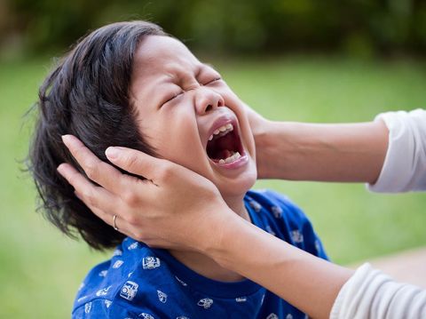 Little asian boy crying bitterly at outdoor. Mom comforting to a crying boy.