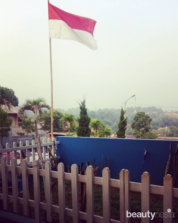 Memasang bendera di depan rumah