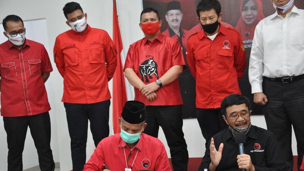 Ketua DPD PDIP Sumut Djarot Saiful Hidayat (kanan) pasangan calon Wali Kota dan Wakil Wali Kota Medan Bobby Nasution (kedua kiri) dan Aulia Rahman (kiri) usai pengumuman rekomendasi calon kepala daerah secara virtual di Medan, Sumatera Utara, Selasa (11/8/2020). DPP Partai Demokrasi Indonesia (PDI) Perjuangan resmi mengusung menantu Presiden Joko Widodo Bobby Nasution dan Aulia Rahman sebagai pasangan calon Wali Kota dan Wakil Wali Kota Medan pada pemilihan kepala daerah (Pilkada) serentak 2020. ANTARA FOTO/Septianda Perdana/foc.