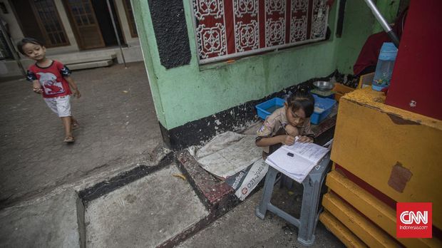 Siswi kelas 2 SDN 01 Pagi Bukit Duri ,Keysha (8) menjalankan proses belajar daring bersama ibunya, Okta (31) di gerai makanan tempat ibunya bekerja di kawasan Bukit Duri, Jakarta, Rabu, 12 Agustus 2020. Pembelajaran Jarak Jauh (PJJ) dengan menggunakan metode daring dan bimbingan orang tua masih menjadi kendala, menurut Okta selain harus mencari nafkah untuk keluarganya Ia harus tetap membimbing anaknya belajar di tempatnya bekerja. CNN Indonesia/Bisma Septalisma