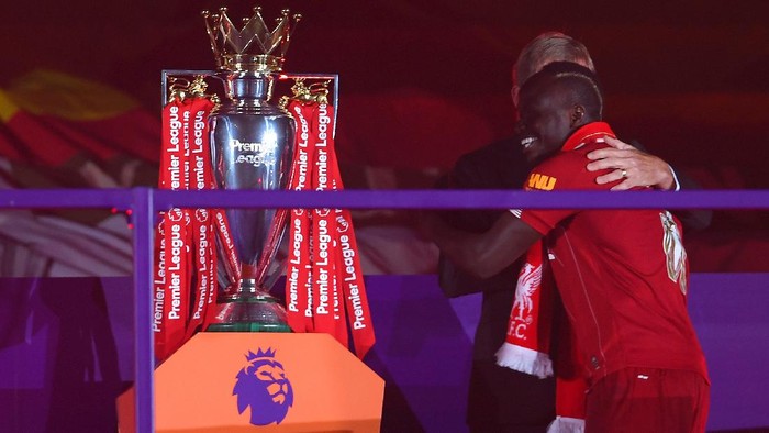 LIVERPOOL, ENGLAND - JULY 22: Sadio Mane of Liverpool embraces Sir Kenny Dalglish, Former Captain and Manager of Liverpool upon receiving a Premier League Winners medal following the Premier League match between Liverpool FC and Chelsea FC at Anfield on July 22, 2020 in Liverpool, England. Football Stadiums around Europe remain empty due to the Coronavirus Pandemic as Government social distancing laws prohibit fans inside venues resulting in all fixtures being played behind closed doors. (Photo by Laurence Griffiths/Getty Images)