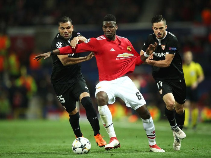 MANCHESTER, ENGLAND - MARCH 13:  Paul Pogba of Manchester United battles with Gabriel Mercado and Pablo Sarabia of Sevilla during the UEFA Champions League Round of 16 Second Leg match between Manchester United and Sevilla FC at Old Trafford on March 13, 2018 in Manchester, United Kingdom.  (Photo by Clive Mason/Getty Images)