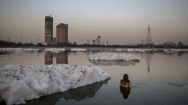 Chemical foam caused by industrial and domestic pollution is seen flowing towards a figurine stuck in the shallow waters of Yamuna river in New Delhi, India, Saturday, Oct. 8, 2019. Despite the river being accorded the status of a living human entity by an Indian court, untreated sewage and industrial pollutants have turned it into one of the most polluted rivers in the world. The river Yamuna is one of the major tributaries of the Ganges. (AP Photo/Altaf Qadri)