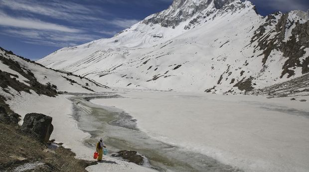 Mouni Baba, a Hindu holy man, fetches water from a stream at the feet of Mount Shivling in Tapovan, at an altitude of 4500 meters in the northern Indian state of Uttarakhand, Friday, May 10, 2019. Mouni Baba, on a silent vow, has been meditating in Tapovan for years, even during the long months when winter makes the place inaccessible. Tapovan is located just above Gangotri glacier, which is one of the primary sources of water for the Ganges. (AP Photo/Altaf Qadri)