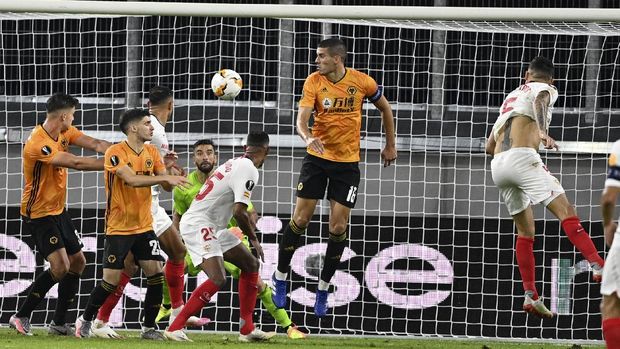 Sevilla's Lucas Ocampos, right, heads the ball to score his team's first goal during the Europa League quarterfinal match between Wolverhampton Wanderers and Sevilla at the MSV-Arena in Duisburg, Germany, Tuesday, Aug. 11, 2020. (Ina Fassbender/Pool Photo via AP)