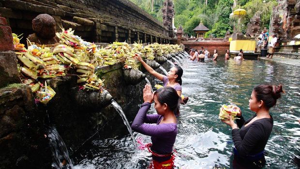 Desa Tampaksiring Bali, Indonesia - May 6, 2013: Worshippers make an offering at the Tirta Empul Temple in Bali, Indonesia.