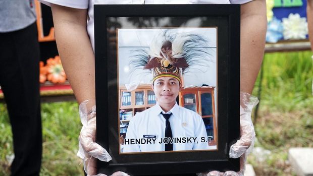 Petugas membawa foto anggota KPU Yakuhimo, Papua almarhum Hendry Jovinski saat proses pemakaman di Rewulu Wetan, Sidokarto, Godean, Sleman, Yogyakarta, Kamis (13/8/2020). Henry Jovinski meninggal dunia diduga menjadi korban pembunuhan oleh orang tak dikenal, pada Selasa (11/8) sore di Papua. ANTARA FOTO/Andreas Fitri Atmoko/wsj.