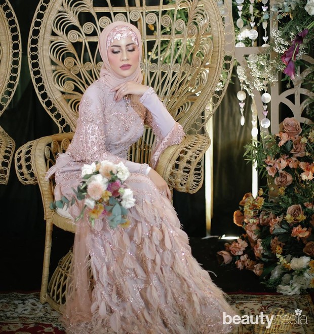 Dengan taburan swarovski di seluruh permukaan gaun membuat Fira tampil mewah