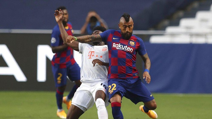 Barcelonas Arturo Vidal, right, holds off Bayerns Alphonso Davies during the Champions League quarterfinal soccer match between Barcelona and Bayern Munich in Lisbon, Portugal, Friday, Aug. 14, 2020. (Rafael Marchante/Pool via AP)