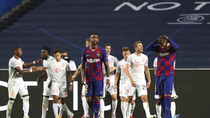 Barcelonas Gerard Pique, right, reacts after Bayerns Philippe Coutinho scored his sides seventh goal during the Champions League quarterfinal soccer match between Barcelona and Bayern Munich in Lisbon, Portugal, Friday, Aug. 14, 2020. (Rafael Marchante/Pool via AP)