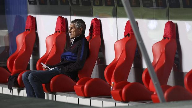 Barcelona's head coach Quique Setien sits on the bench before the start of the second half of the Champions League quarterfinal soccer match between Barcelona and Bayern Munich in Lisbon, Portugal, Friday, Aug. 14, 2020. (Rafael Marchante/Pool via AP)