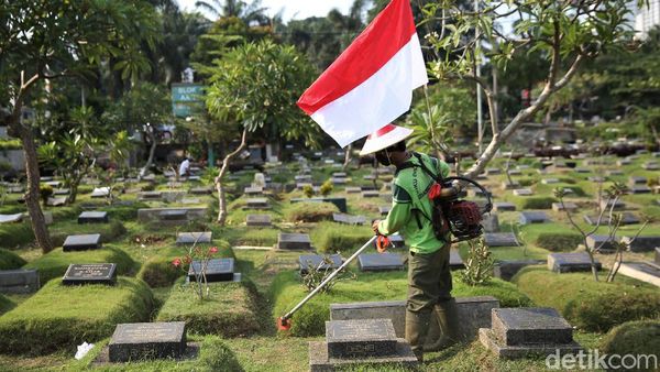 Aksi Petugas Bersihkan TPU Karet Bivak Sambil Bawa Bendera