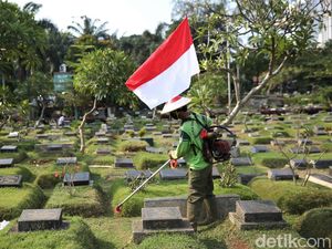Aksi Petugas Bersihkan TPU Karet Bivak Sambil Bawa Bendera