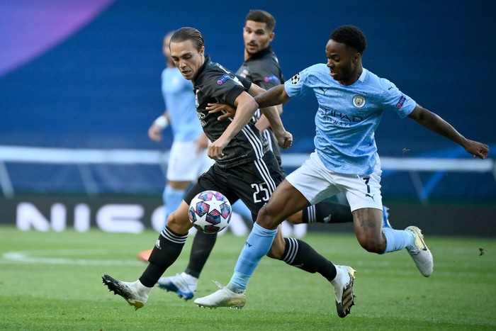 LISBON, PORTUGAL - AUGUST 15: Maxence Caqueret of Olympique Lyon battles for possession with Raheem Sterling of Manchester City during the UEFA Champions League Quarter Final match between Manchester City and Lyon at Estadio Jose Alvalade on August 15, 2020 in Lisbon, Portugal. (Photo by Franck Fife/Pool via Getty Images)