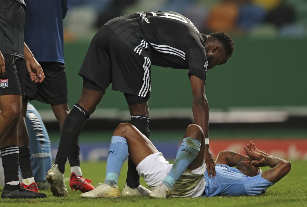 Lyon's Moussa Dembele consoles Manchester City's Raheem Sterling at the end of the Champions League quarterfinal soccer match between Lyon and Manchester City at the Jose Alvalade stadium in Lisbon, Portugal, Saturday, Aug. 15, 2020. Lyon won the match 3-1. (Miguel A. Lopes/Pool via AP)