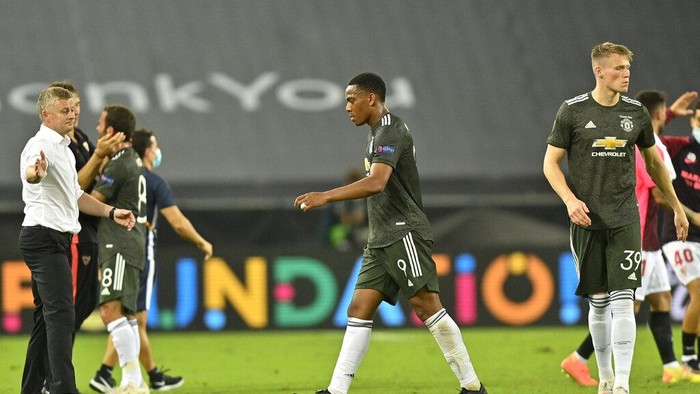 From left, Manchester Uniteds manager Ole Gunnar Solskjaer, Anthony Martial and Scott McTominay leave the field at the end of an Europa League semifinal match between Sevilla and Manchester United, in Cologne, Germany, Sunday, Aug. 16, 2020. Sevilla won 2-1. (AP Photo/Martin Meissner, Pool)