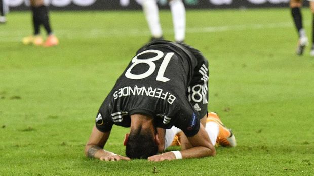 Manchester United's Bruno Fernandes kneels on the ground at the end of an Europa League semifinal match between Sevilla and Manchester United, in Cologne, Germany, Sunday, Aug. 16, 2020. (AP Photo/Martin Meissner, Pool)